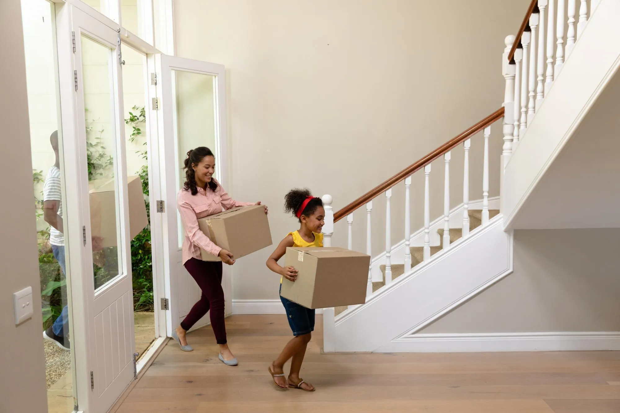 Familie packt gemeinsam Umzugskartons im neuen Zuhause
