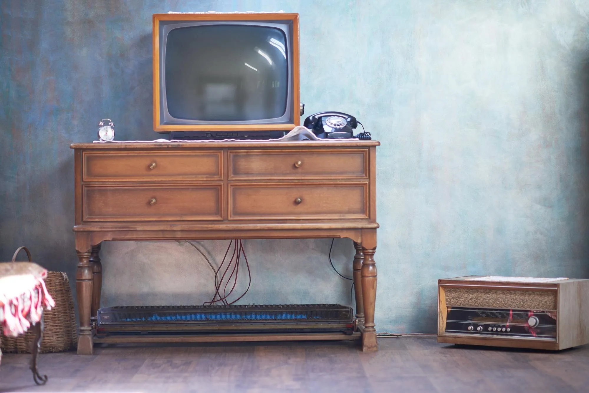 Alte Kommode mit Röhrenfernseher, Wählscheibentelefon und Radio