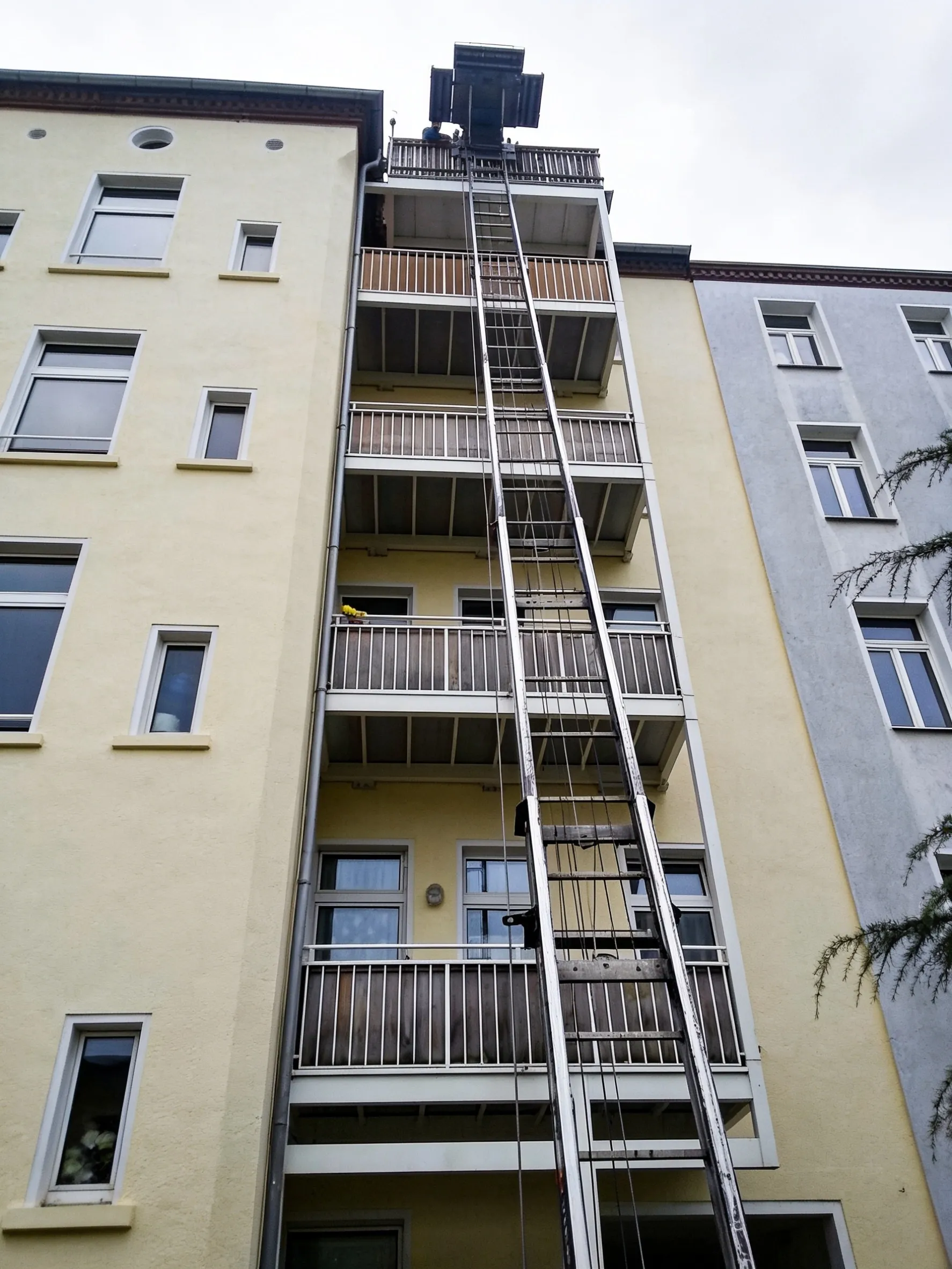 Möbellift von RS Umzugsservice an einem Altbau, ausgefahren bis zum obersten Balkon